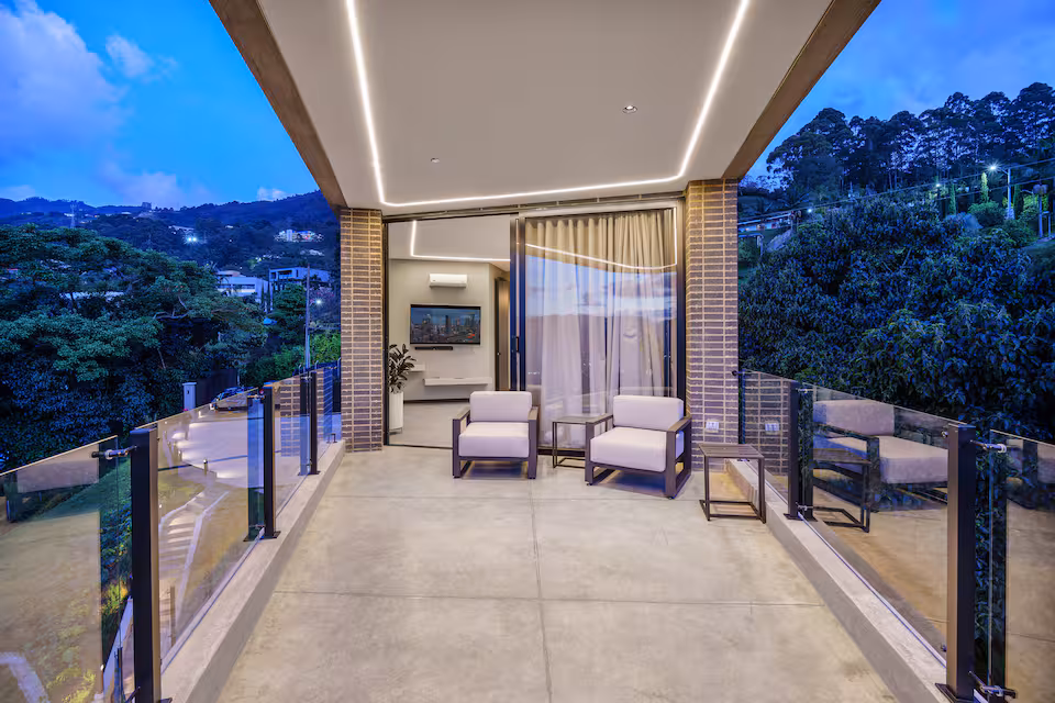 Covered balcony lounge overlooking green hills
