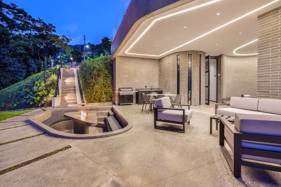 Villa patio with outdoor seating, grill, and garden walkway