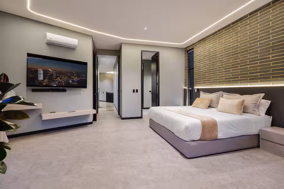 Villa bedroom with neutral bedding and modern lighting