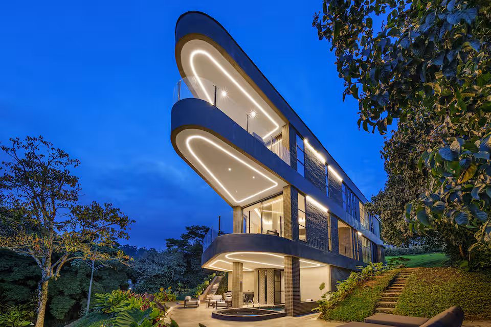 Exterior of the Medellin retreat villa at dusk with illuminated balconies